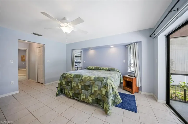 Tiled bedroom with access to outside and ceiling fan