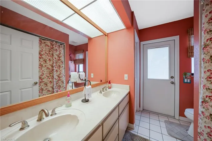 Bathroom featuring toilet, vanity, and tile patterned floors