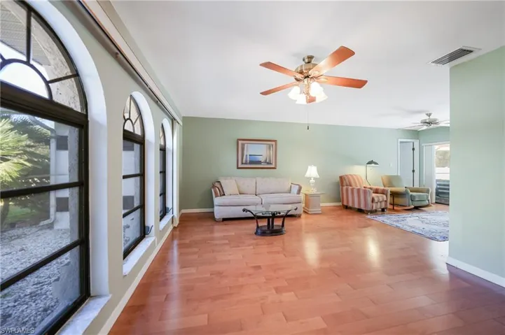 Living room with ceiling fan and light hardwood / wood-style floors