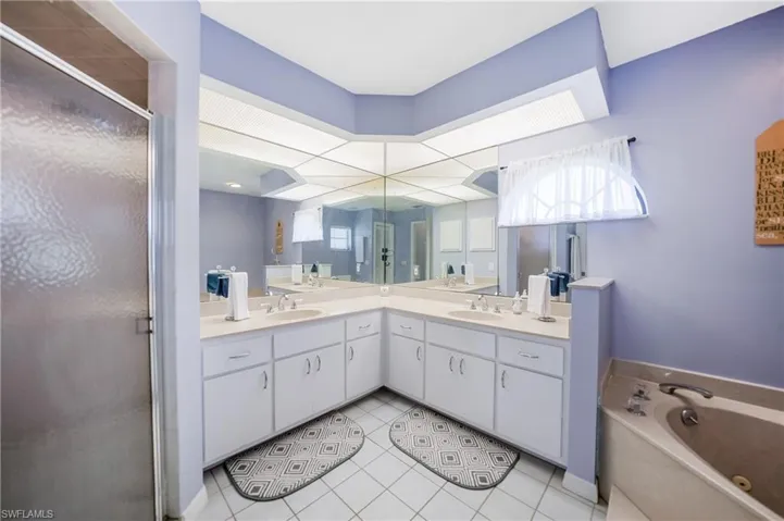 Bathroom featuring separate shower and tub, tile patterned floors, and vanity