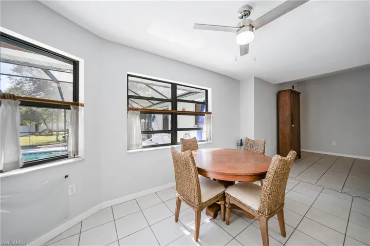 Tiled dining area featuring a wealth of natural light and ceiling fan