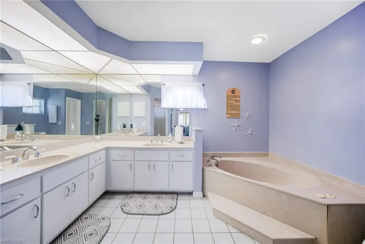 Bathroom featuring vanity, tile patterned floors, and a bathtub