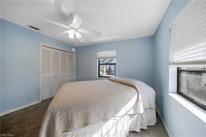 Carpeted bedroom with a closet and ceiling fan