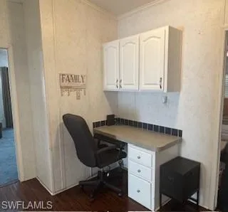 Office space featuring dark wood finished floors and crown molding