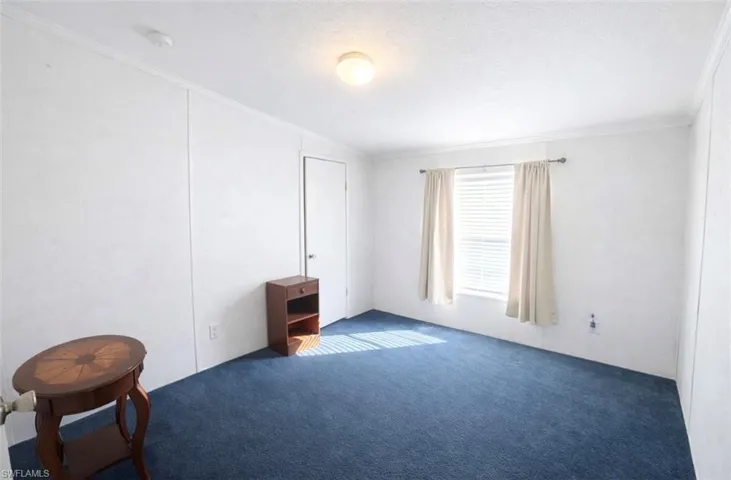 Unfurnished bedroom featuring ornamental molding, carpet floors, and a textured ceiling