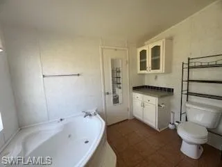 Full bath with vanity and a jetted tub