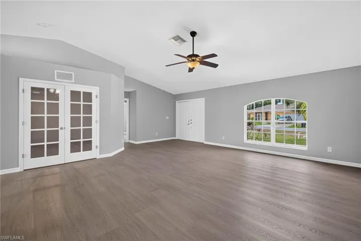 Living room facing den on left, minor bedrooms in middle, and front door on right