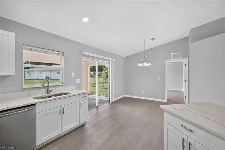 Kitchen facing dining room with lanai on left and minor bedroom entry on right