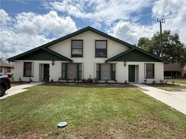 View of front of property featuring a front lawn and stucco siding