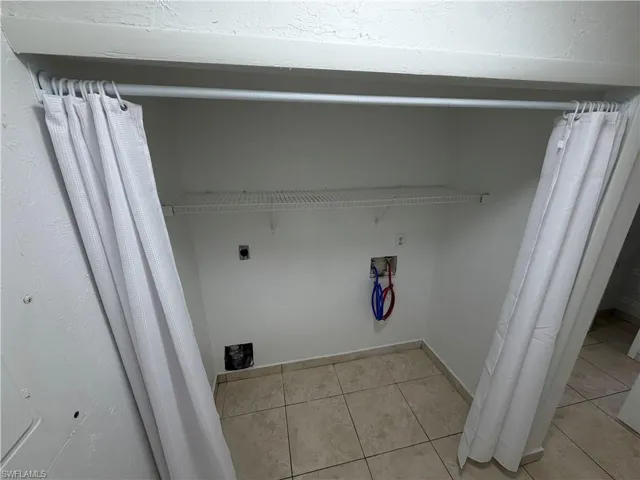Laundry area featuring washer hookup, light tile patterned floors, and electric dryer hookup