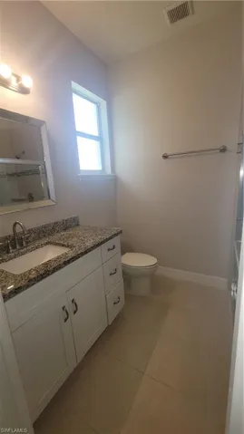 Master bathroom with vanity, a shower with door, and tile patterned floors