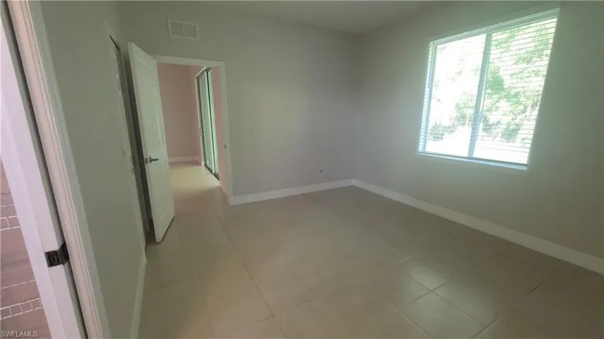 Master bedroom featuring baseboards and light tile patterned floors