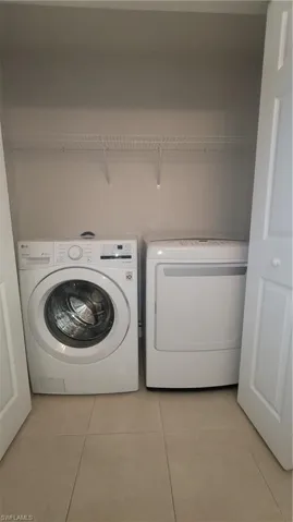 Laundry room featuring light tile patterned floors and washer and dryer