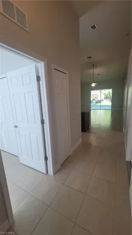 Hallway with light tile patterned floors and baseboards