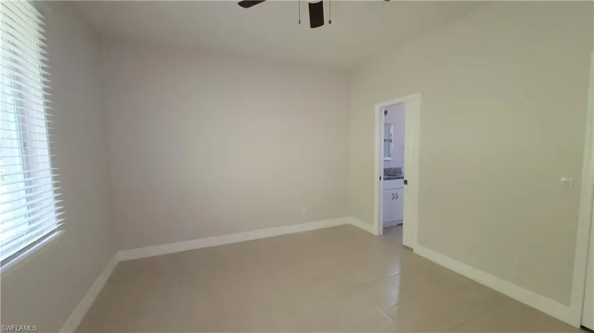 Master bedroom featuring a ceiling fan and light tile patterned floors