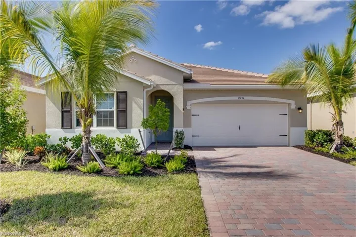 View of front of property with stucco siding, decorative driveway, a tiled roof, an attached garage, and a front yard