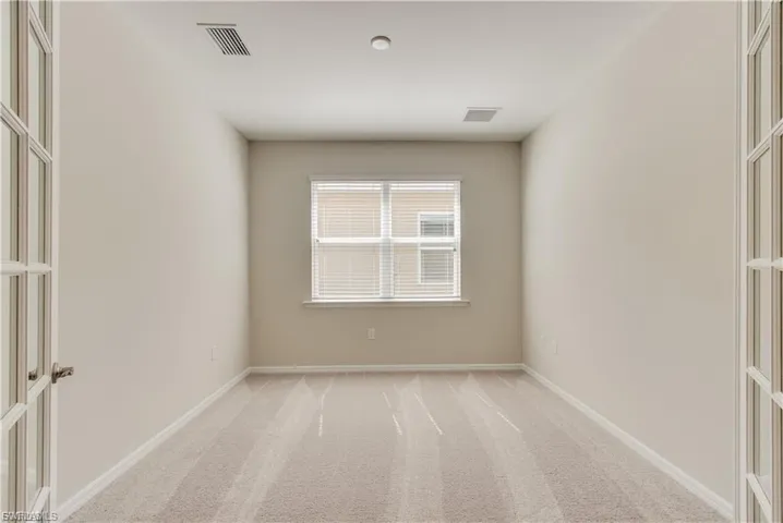 Spare room featuring light colored carpet and french doors