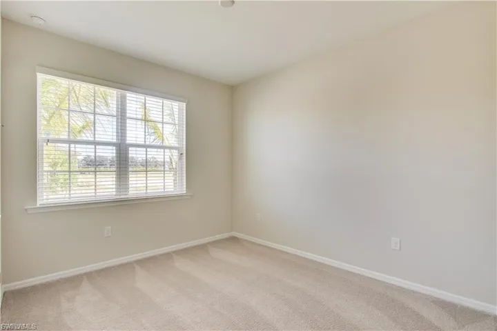 Spare room featuring light carpet and baseboards