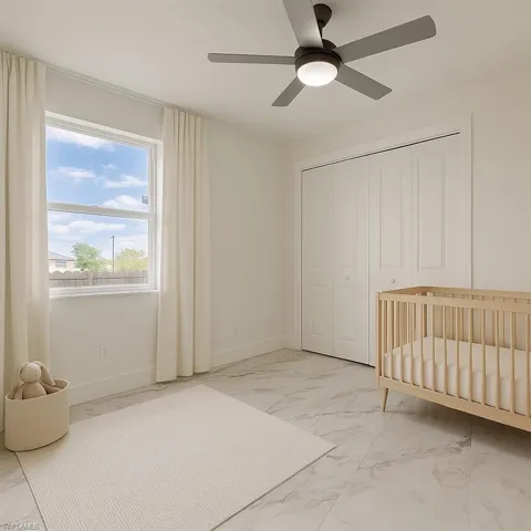 Unfurnished bedroom with marble look tiles, a closet, and a ceiling fan