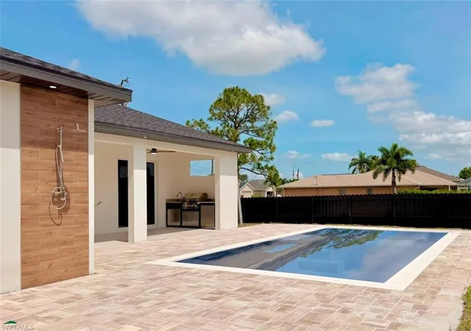 View of swimming pool with an outdoor kitchen, a patio, and ceiling fan