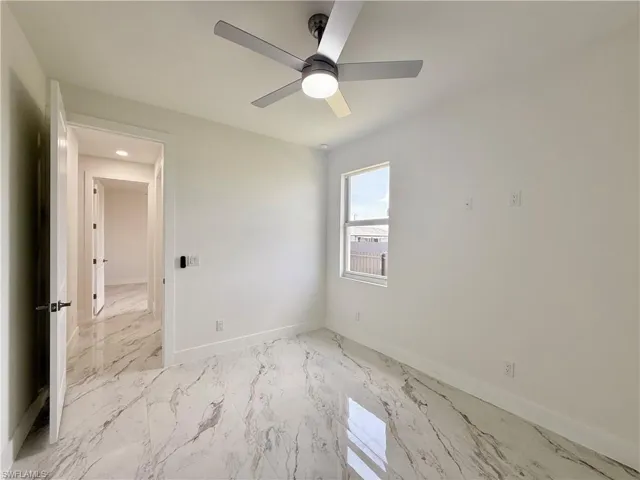 Empty room featuring light marble finish flooring, ceiling fan, baseboards, and recessed lighting
