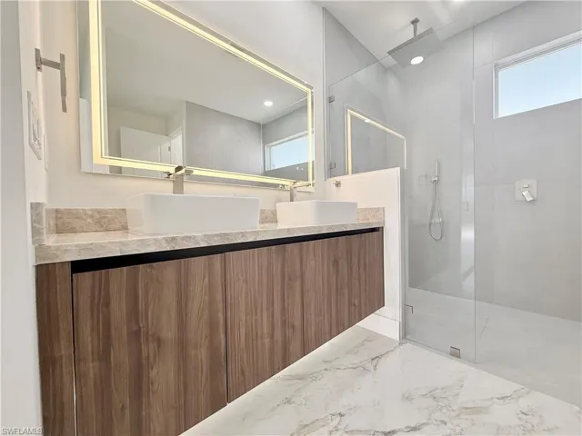 Master -Full bathroom featuring a walk in shower, vanity, and marble tiled floors