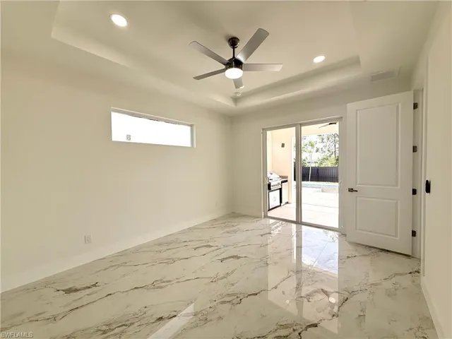 Master room featuring a tray ceiling, baseboards, recessed lighting, a ceiling fan, and light marble finish flooring