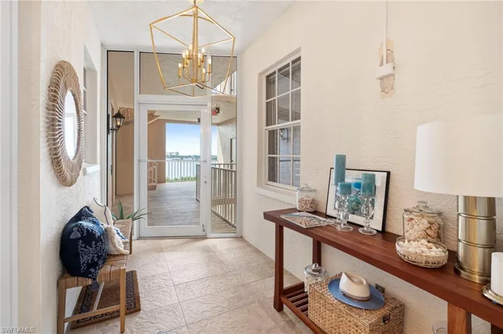 Foyer featuring a textured ceiling, light tile patterned floors, and a chandelier