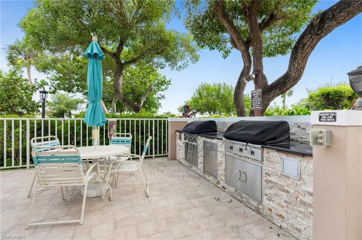 View of patio with area for grilling and a grill
