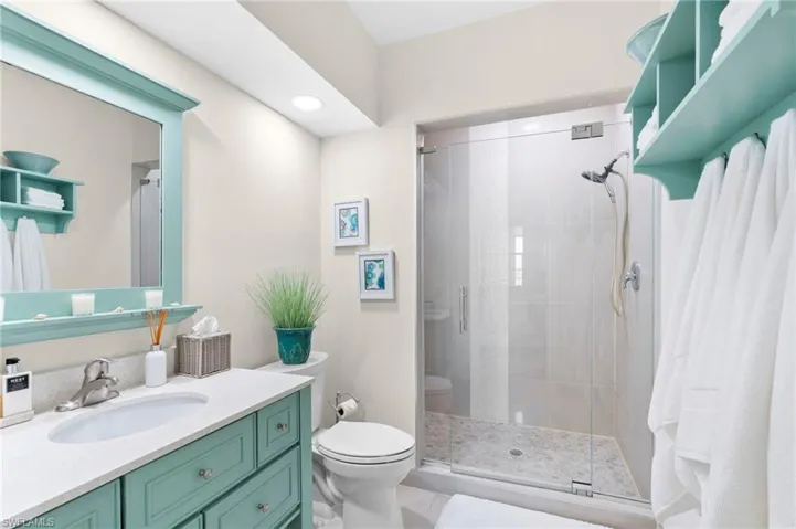 Bathroom featuring vanity, toilet, and walk in shower