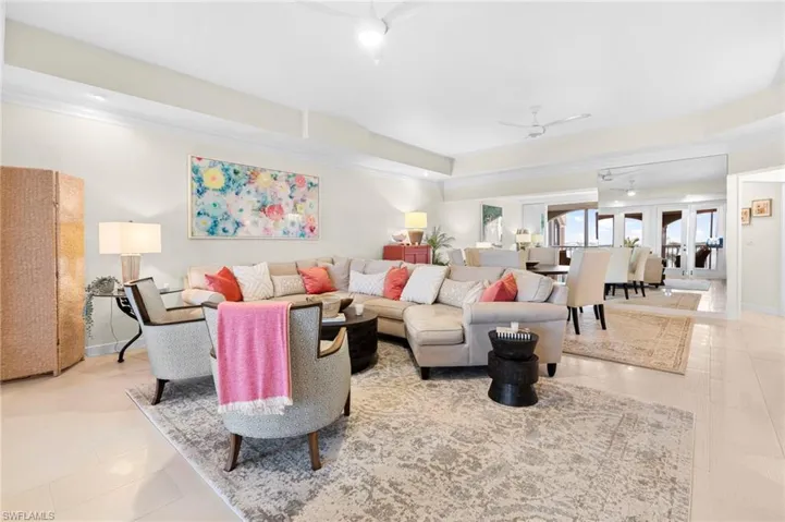 Living room with french doors, ceiling fan, light tile patterned floors, and ornamental molding