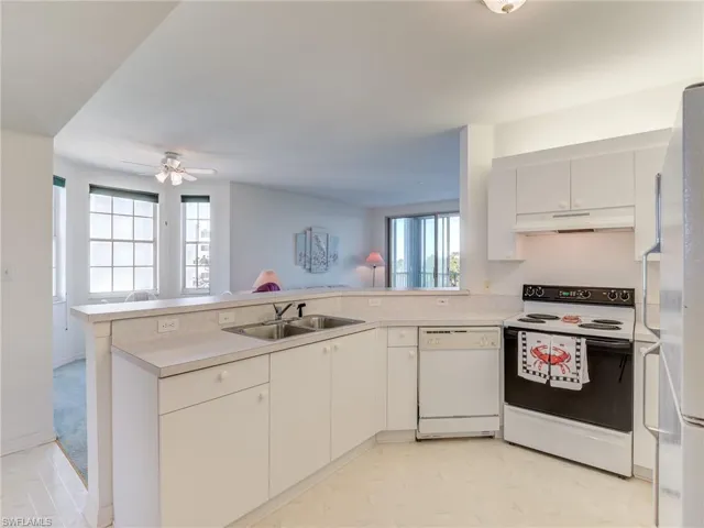 Kitchen featuring electric range, white dishwasher, light countertops, and white cabinets