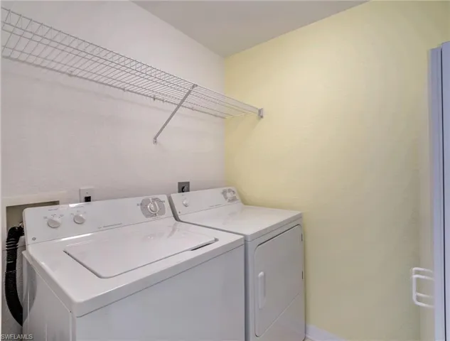 Laundry area featuring washing machine and dryer and baseboards