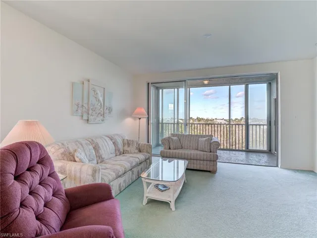 Carpeted living area featuring baseboards