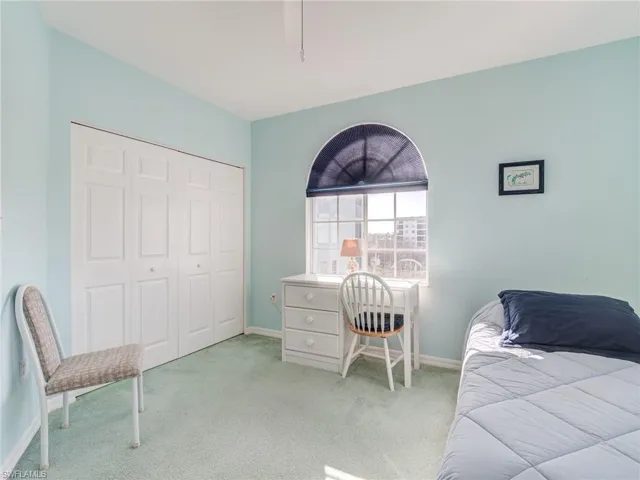 Bedroom with carpet, a closet, and a ceiling fan