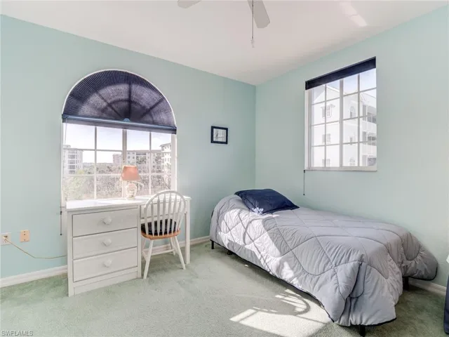 Carpeted bedroom with baseboards and ceiling fan