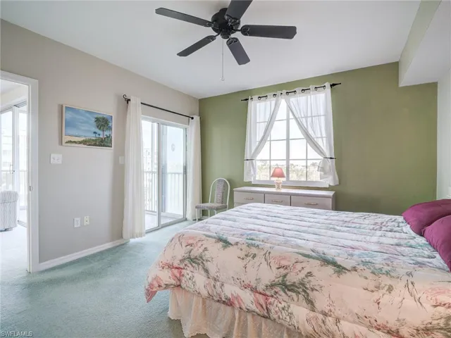 Carpeted bedroom featuring access to exterior and ceiling fan