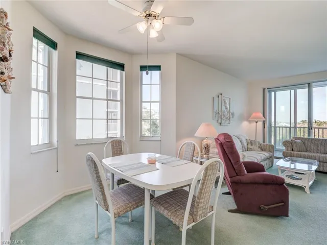 Carpeted dining room featuring a ceiling fan and baseboards