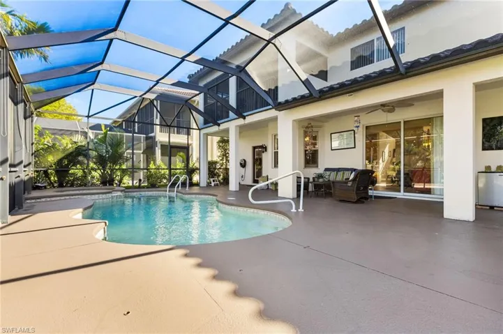 View of swimming pool featuring glass enclosure, ceiling fan, a patio, and an outdoor living space