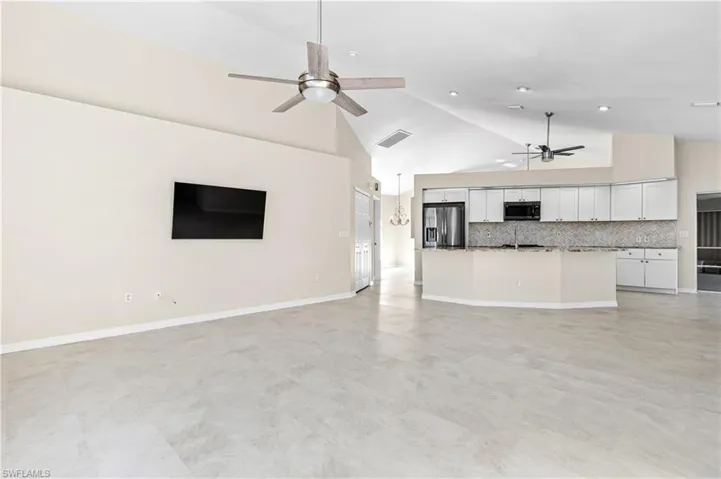 Large living room featuring high vaulted ceiling and a ceiling fan