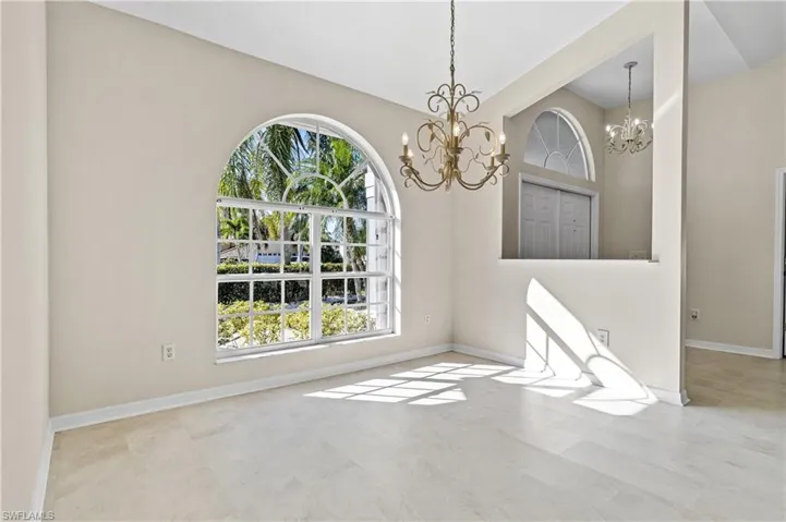 Empty room featuring baseboards and a high ceiling