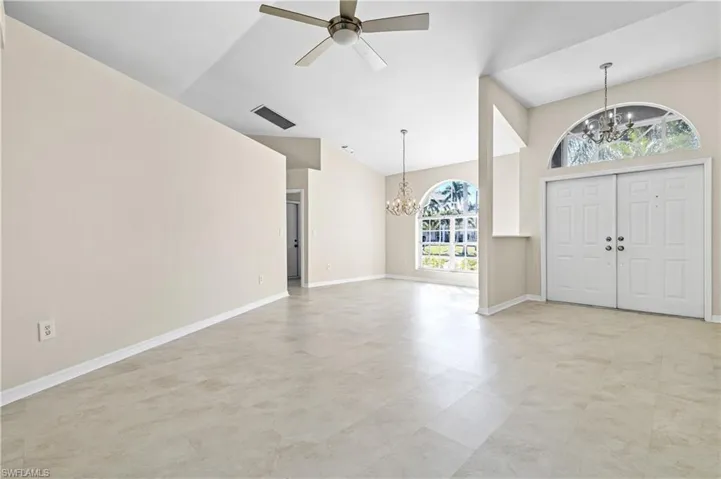 Entryway featuring a chandelier, a ceiling fan, and high vaulted ceiling