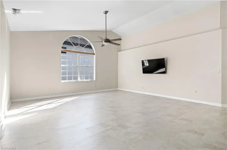 Large living room with lofted ceiling and a ceiling fan