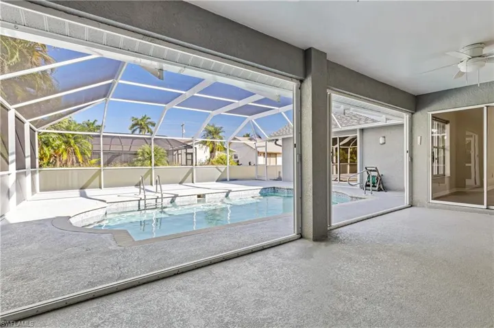 Swimming pool featuring a ceiling fan, a large enclosed lanai with shutters
