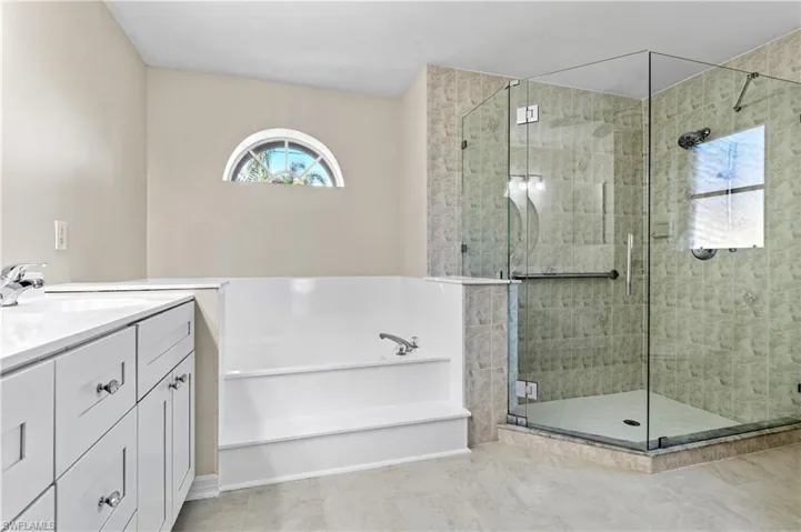 Master Bathroom featuring a garden tub, vanity, full glass enclosed shower