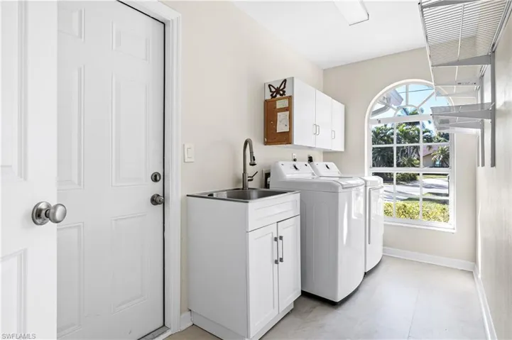 Laundry area with cabinet space and washing machine and clothes dryer
