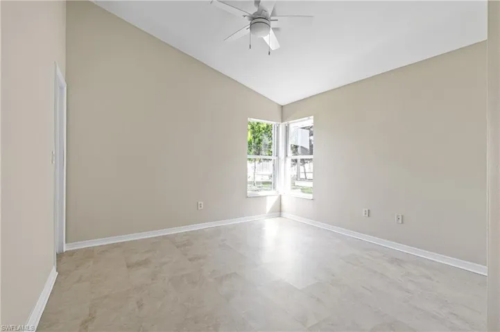 Rear guest bedroom featuring lofted ceiling and a ceiling fan