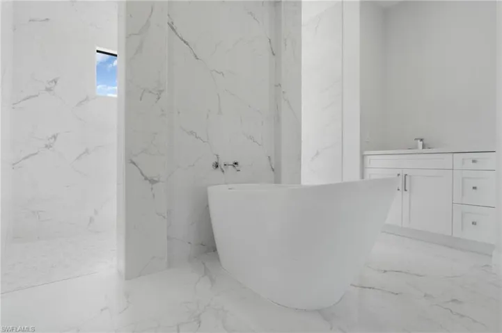 Bathroom featuring sink, tile patterned flooring, and tile walls