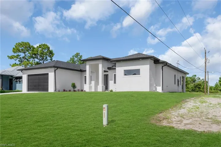 Prairie-style home featuring a garage and a front lawn