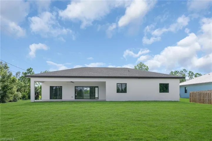 Back of house with a patio, a yard, and ceiling fan